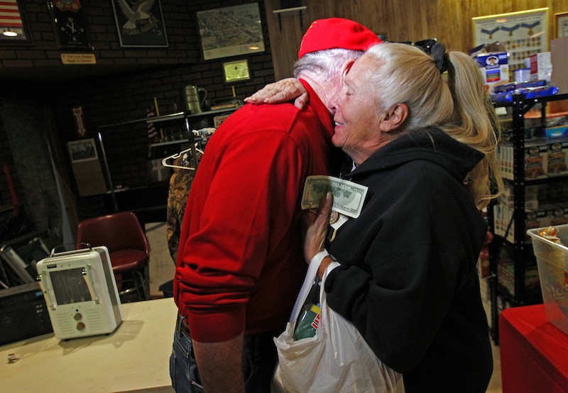 Carol Hefty hugs Secret Santa after he gave her a $100 dollar bill while she was looking for supplies at a temporary supply house at the Oakwood Heights VFW Post 9587 in the boro of Staten Island, New York, N.Y., Thursday, Nov. 29, 2012. The wealthy philanthropist from Kansas City, Mo. Secret Santa distributed $100 dollar bills to needy people at several locations in Elizabeth, N.J. and Staten Island.