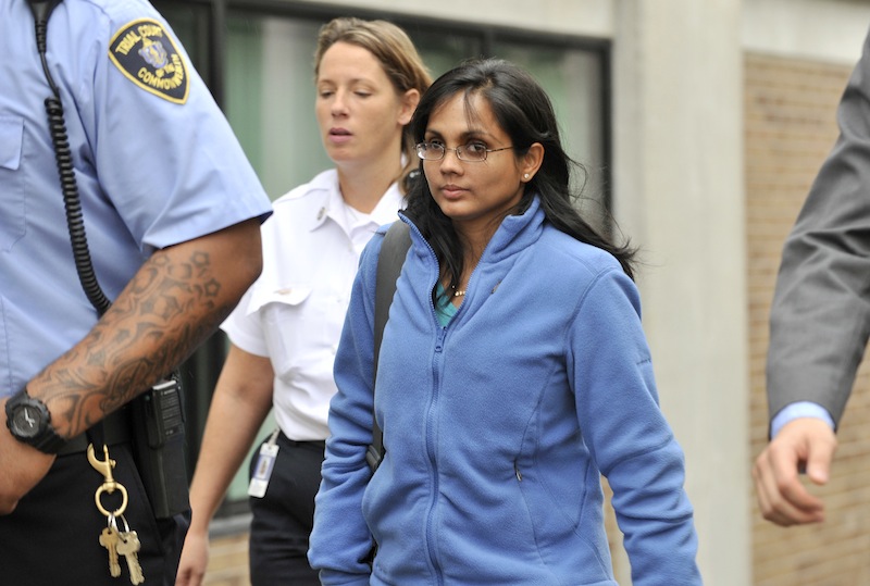 Annie Dookhan, center, leaves a Boston courthouse on Oct. 10 escorted by court officers and her lawyer. Gov. Deval Patrick has ordered a "file-by-file review" of every case handled by Dookhan, a Massachusetts chemist accused of faking test results at a now-closed government lab, as authorities continue to deal with the fallout from a scandal that threatens to unravel thousands of criminal cases.