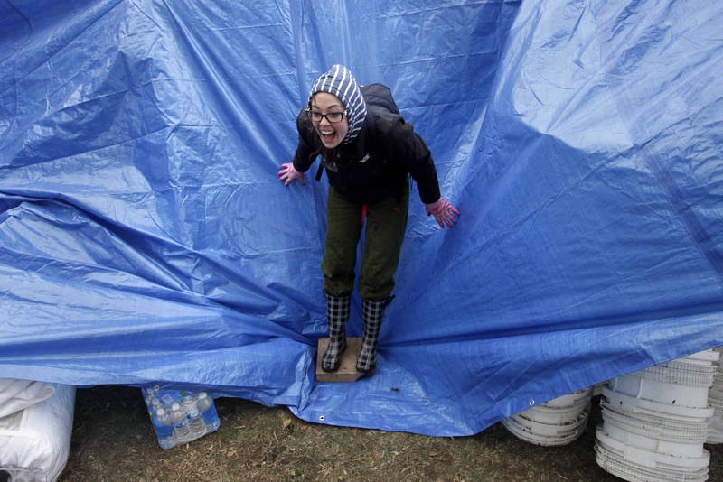 Gina Kohm reacts as a gust of wind almost rips a tarp off of a pile of donated supplies at an aid station on Staten Island, New York on Wednesday. Residents of New York and New Jersey who were flooded out by superstorm Sandy are waiting with dread Wednesday for the second time in two weeks as another, weaker storm heads toward them.