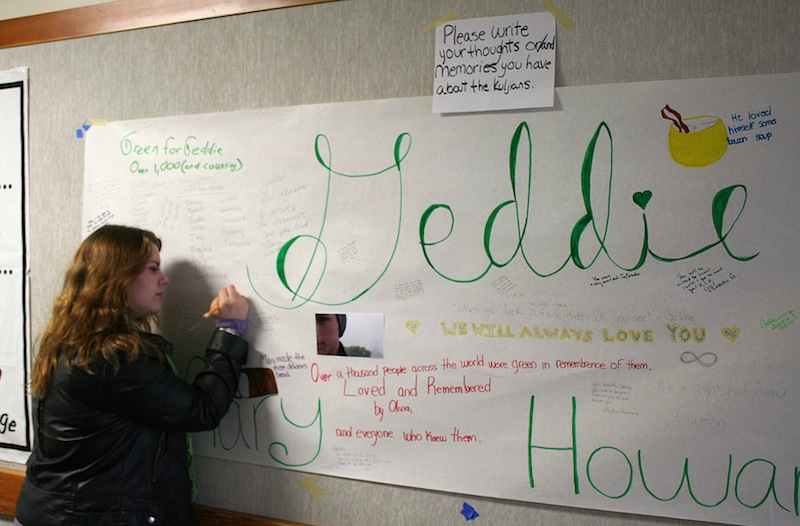 In this photo provided by the Arcata High School Pepperbox, Arcata High School student Blaire Floyd writes on a poster memorial for fellow student Gregory Kulijan Monday, Nov. 26, 2012, at Arcata High School in Arcata, Calif. The Kuljian family were out for a walk Saturday, Nov. 24 at Big Lagoon beach, playing fetch with their dog when Gregory Kuljian tossed a stick that took their dog down to the water's edge. Kuljian's son ran to save the dog, and struggled as he was captured by the surging surf. Howard Kuljian followed, and later his wife. Both parents' bodies were later recovered, but the boy, presumed dead, is still missing. (AP Photo/Courtesy Forrest Lewis, Arcata High School Pepperbox)