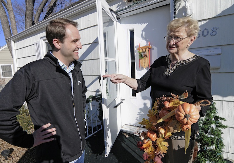 Jake Loesch and his grandmother, Bunny Arseneau pose outside Bunny's home where they replaced the Thanksgiving ornament with one for Christmas on the front door, Tuesday, Nov. 20, 2012 in Crystal, Minn. The issue dividing the family at the Thanksgiving table will be gay marriage. Although Arceneau disagreed with her grandson who was deputy communications director for Minnesotans United for All Familes which opposed Minnesota's gay marriage amendment, she congratulated her grandson on his stance. (AP Photo/Jim Mone)