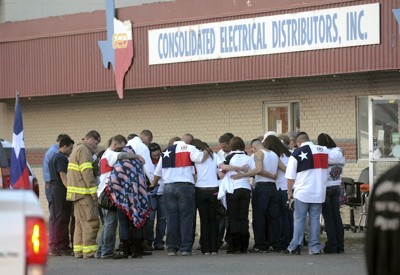 Parade participants and pubic safety officials huddle after a trailer carrying wounded veterans in a parade was struck by a train in Midland, Texas, Thursday, Nov. 15, 2012. "Show of Support" president and founder Terry Johnson says there are "multiple injuries" after a Union Pacific train slammed into the trailer, killing at least four people and injuring 17 others. (AP Photo/Reporter-Telegram, James Durbin) MRT;accident;wreck;crash;armed forces