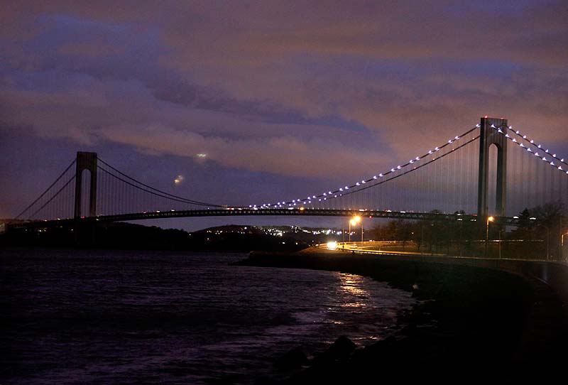 The half of the Verrazano Narrows Bridge attached to Brooklyn is lit while the half attached to Staten Island is dark in New York on Friday.
