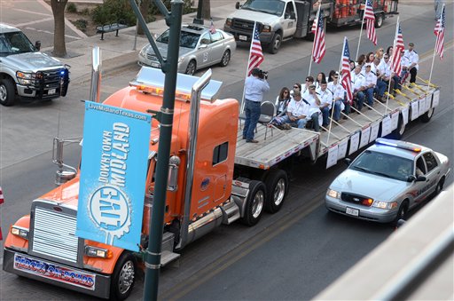 A flatbed truck carries wounded veterans and their families during a parade before it was struck by a train Thursday, Nov. 15, 2012 in Midland, Texas. "Show of Support" president and founder Terry Johnson says there are "multiple injuries" after a Union Pacific train slammed into the trailer, killing at least four people and injuring 17 others. (AP Photo/Reporter-Telegram, James Durbin) MRT;accident;wreck;crash;armed forces
