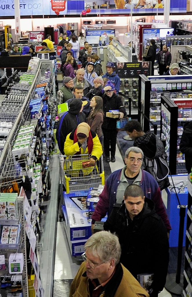 Black Friday shoppers wait in the checkout line just after midnight at the Best Buy in the Maine Mall in South Portland on Friday.