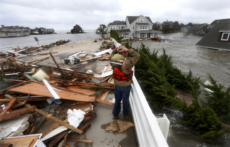 Brian Hajeski, 41, of Brick, New Jersey, reacts as he looks at debris of a home that washed up on to the Mantoloking Bridge after Hurricane Sandy rolled through.