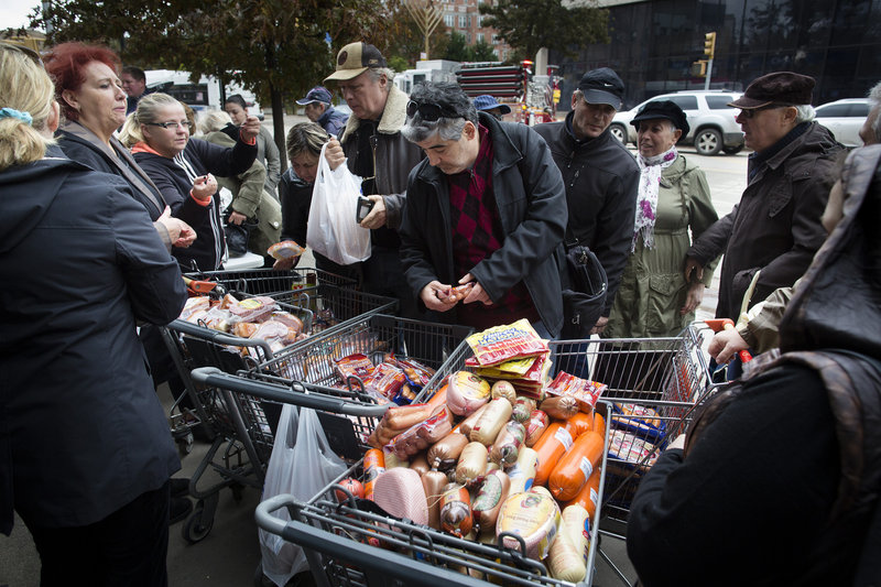People shop for food piled into shopping carts in Brooklyn, N.Y., after Hurricane Sandy closed stores.