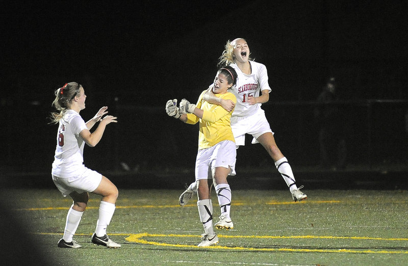It's time to celebrate for the Scarborough girls' soccer team as Sam Sparda, left, and Ainsley Jamieson, right, mob goalie Sydney Martin after a 1-0 win over Cape Elizabeth Wednesday for the Western Class A girls' championship.
