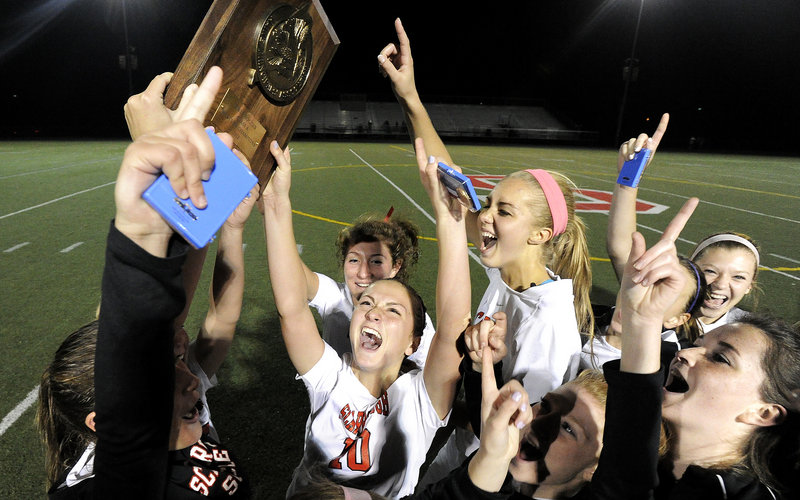The Scarborough High girls hoist the trophy after beating Cape Elizabeth 1-0 for the Western Class A championship Wednesday.