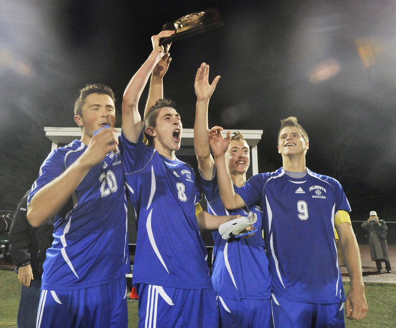 Falmouth’s Jack Pike, left, Cooper Lycan, Grant Burfeind and JP White raise their trophy after topping Yarmouth 2-0 for the Western Class B soccer championship Wednesday.
