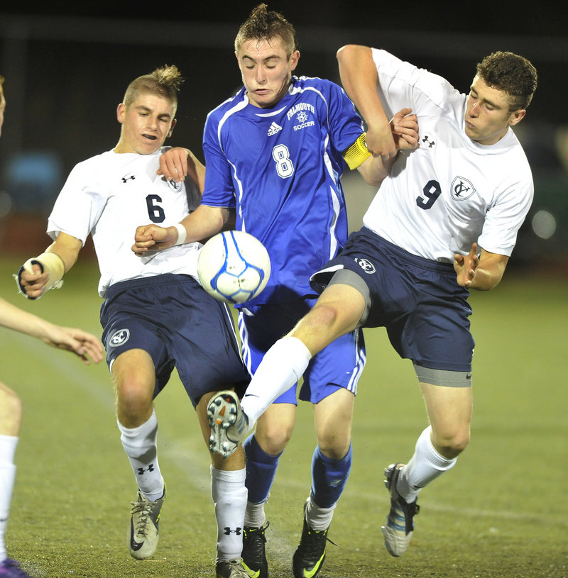 Mike Smith, left, and Max Watson of Yarmouth try to squeeze out Falmouth’s Cooper Lycan to gain control of the ball in Wednesday night’s Western Class B championship match. Falmouth produced a 2-0 win.