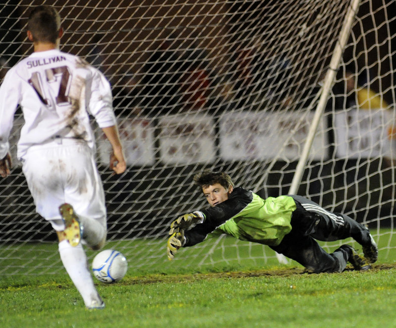 Gorham goalie Alex McCarthy dives to try to make a save, but a shot by Sam Cedaka of Scarborough eludes him for the only goal of the game Wednesday night in the Western Class A boys’ soccer final at Gorham.