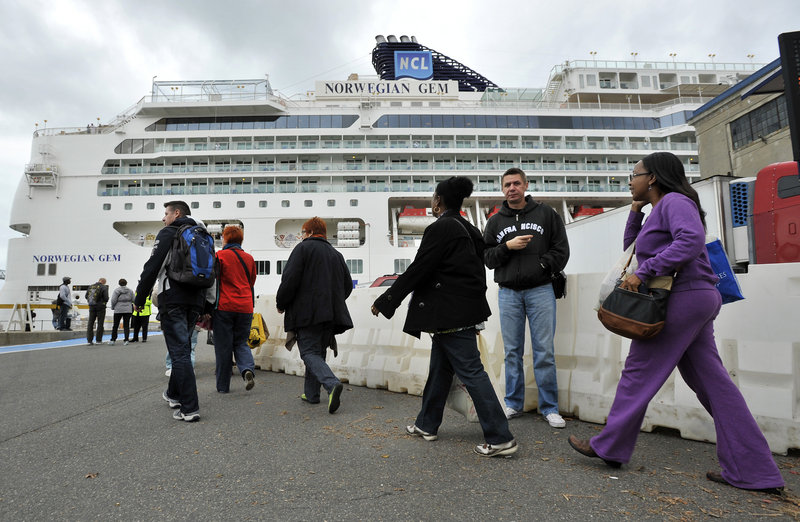 Passengers walk toward the Black Falcon Cruise Terminal in Boston, where they docked on Wednesday.