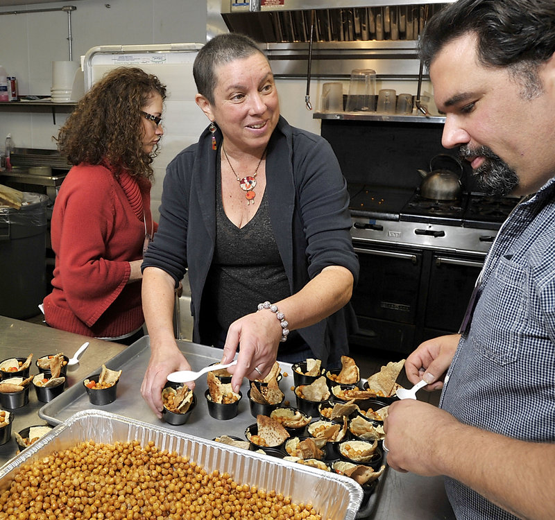 Kathy Gunst, a chef and cookbook author, helps Mike Fitzgerald and other parents at the South Berwick school get lunch ready after a hands-on lesson in healthy foods.