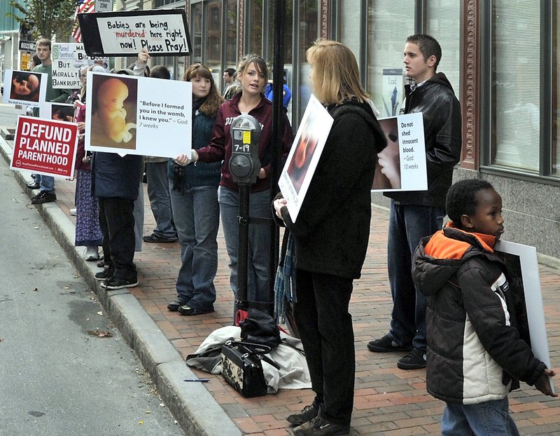 Anti-abortion demonstrators protest outside Planned Parenthood of New England on Congress Street in Portland on Oct. 19. One reader says that the posters drive home the ugly reality of abortion. According to another reader, who attended an earlier counterprotest, opponents of abortion used the posters to block the path of a woman walking past.