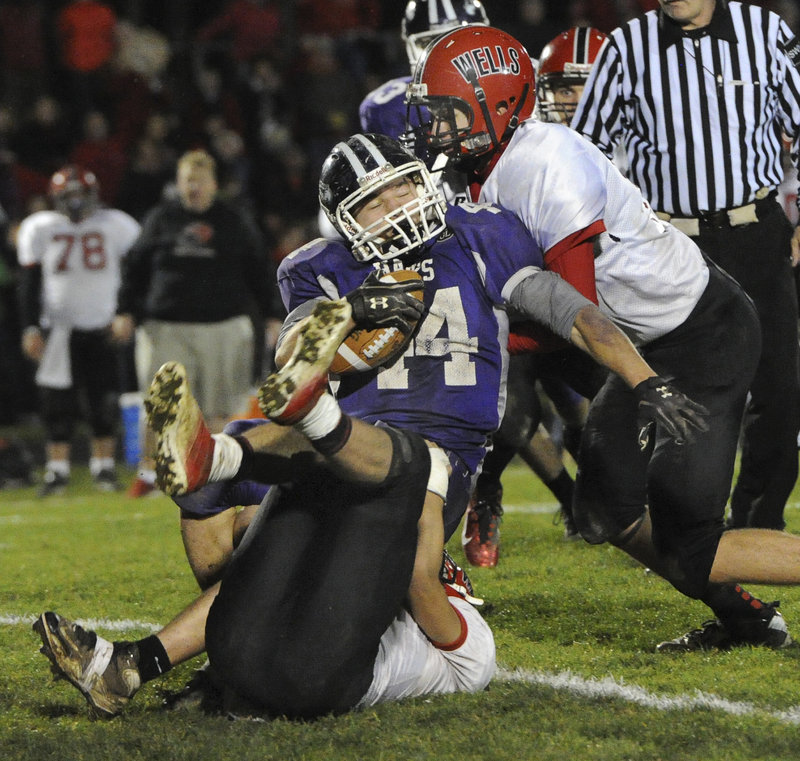 Brett Gerry is brought down – but not for long – by Wells’ Ryan Marsh (17) and Dylan Stevens (12) in Friday’s Western Class B football semifinal, won by Marshwood.
