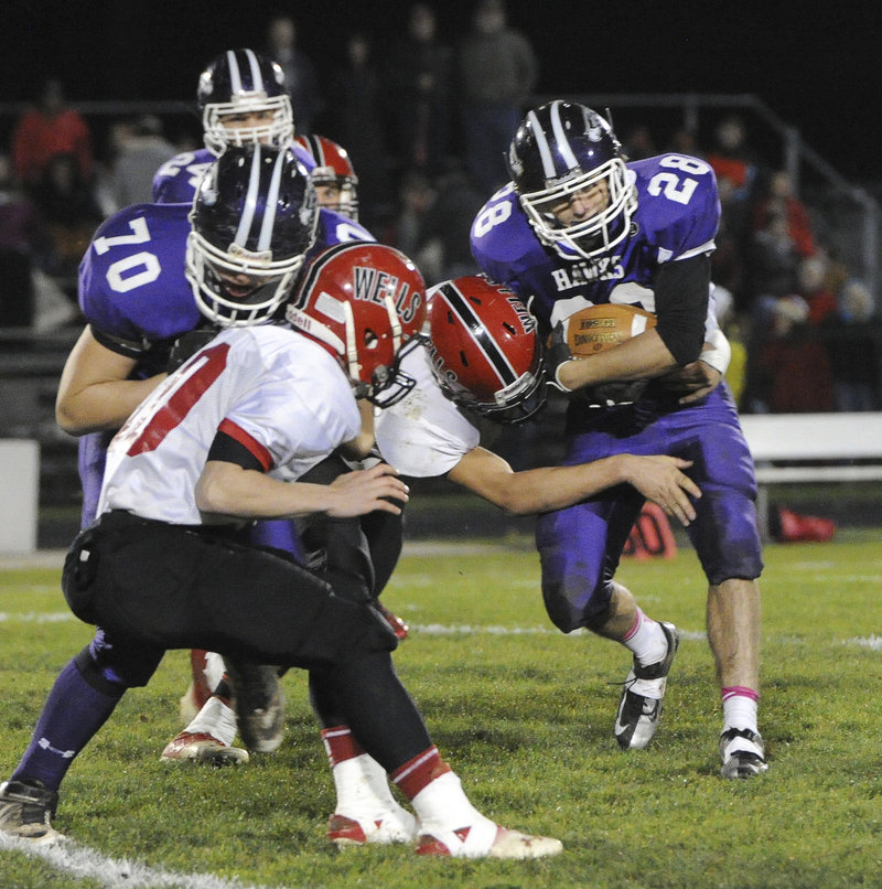 Nick Janes crashes through the Wells defense Friday night. A fine two-way player, Janes also intercepted a fourth-quarter pass to end the Warriors’ hopes for a comeback in the Western Class B semifinal in South Berwick.