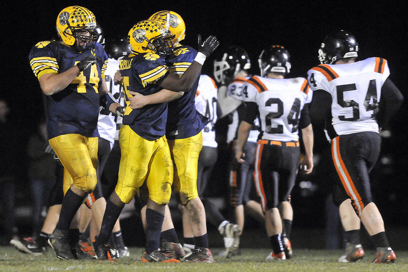 Kindle Bonsall, center, celebrates with quarterback Jordan Whitney, right, after catching a 24-yard touchdown pass in the second quarter of Mt. Blue’s 33-21 win over Gardiner.