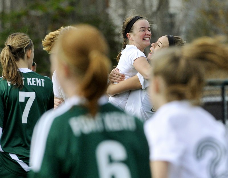 Isabel Agnew, center, gets a hug from Sadie Cole after Cole scored Waynflete’s first goal Saturday in the Class C girls’ soccer final against Fort Kent. Agnew assisted on Cole’s goal, then scored the winner midway through the second half as Waynflete rallied for a 3-2 victory.