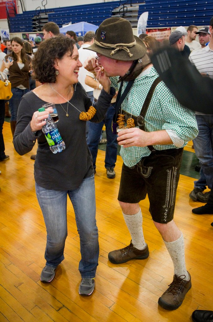 Julie Nadeau of Brighton, Mass., shares her pretzel necklace with Paschal Healy, who flew from Ireland to attend the Maine Brewers Festival at the Portland Expo on Saturday.