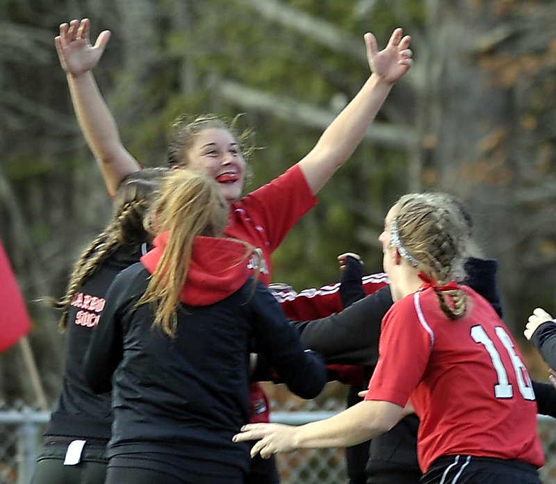 Sarah Martens, rear, is swarmed by her teammates after her overtime goal Saturday gave Scarborough a 2-1 win over Bangor in the C lass A girls’ soccer final.