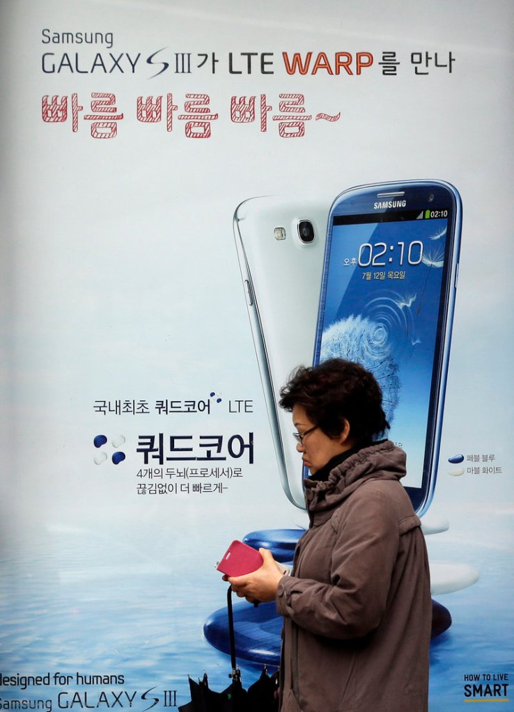 A woman walks near an advertisement for Samsung’s Galaxy S III smartphone in Seoul, South Korea, on Monday. Samsung said it has sold more than 30 million of the phones in about five months, making it one of the fastest-selling smartphones in the world.