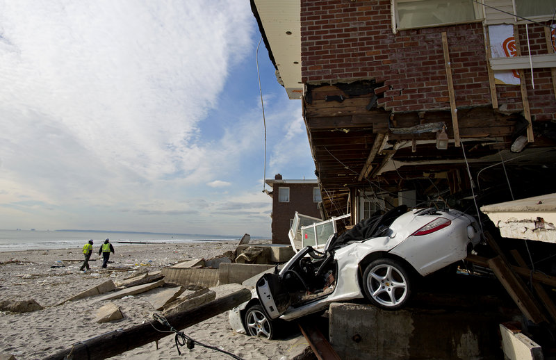 A vehicle sits embedded in a badly damaged home along the beach in the Belle Harbor section of the New York City borough of Queens on Monday in the wake of Superstorm Sandy. Tens of thousands of people without power along the ravaged Atlantic coastline faced the prospect of finding somewhere else to stay.