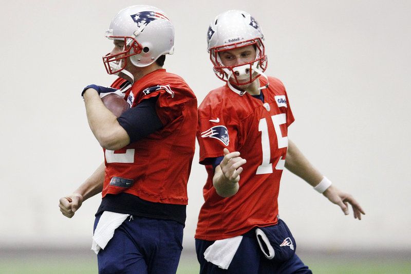 Tom Brady, left, and backup quarterback Ryan Mallett participate in a ballhandling drill during the New England Patriots’ practice Wednesday in Foxborough, Mass.
