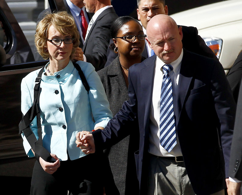 Former Rep. Gabrielle Giffords, left, and her husband, Mark Kelly, leave court after the sentencing of Jared Lee Loughner on Thursday in Tucson, Ariz. U.S. District Judge Larry Burns sentenced Loughner to life in prison for the January 2011 attack that left six people dead and Giffords and others wounded.