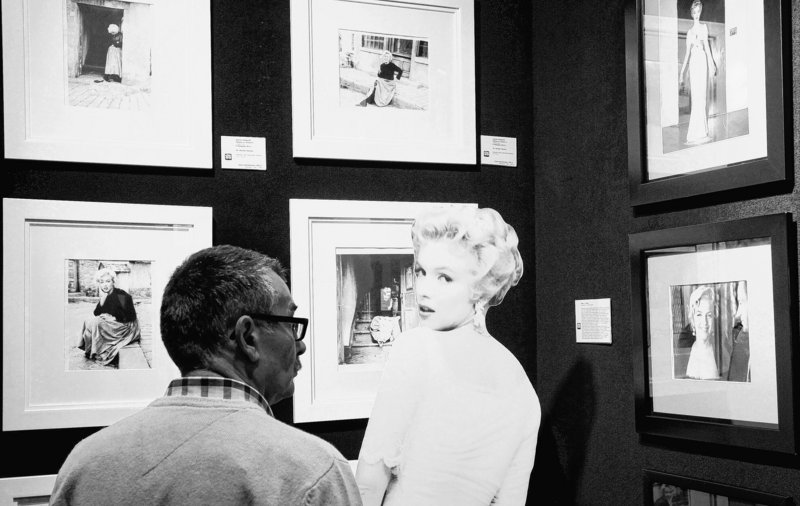 A potential bidder looks at Marilyn Monroe photos prior to an auction of pictures by the late celebrity photographer Milton H. Greene in Warsaw, Poland.