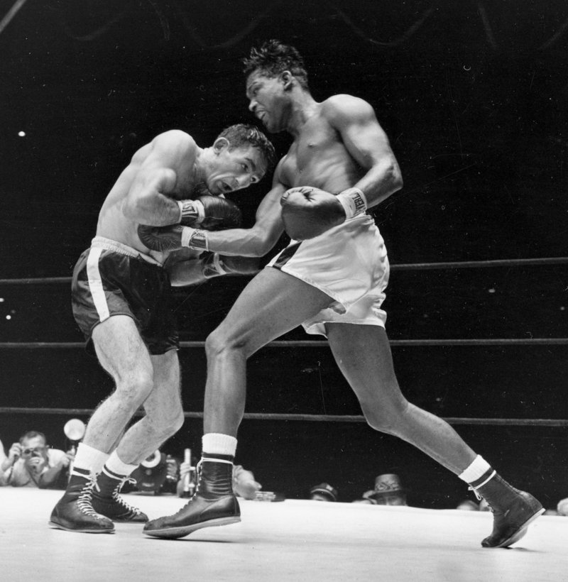 Carmen Basilio, left, bores during his upset of world middleweight champion Sugar Ray Robinson at Yankee Stadium on Sept. 23, 1957.