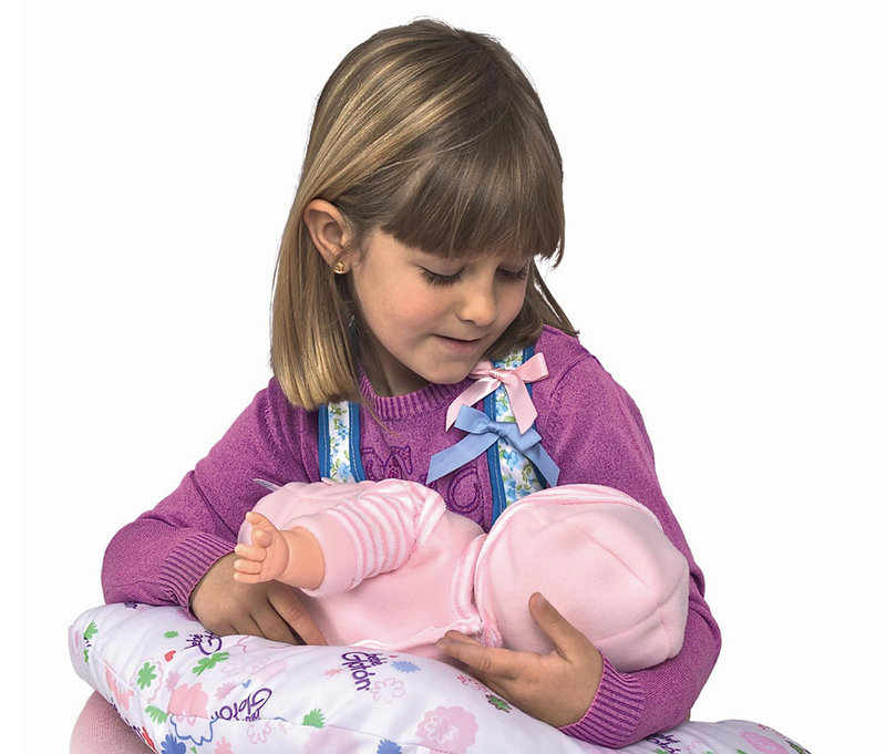 An image from Berjuan Toys shows a girl playing with the Breast Milk Baby doll, which makes suckling sounds when prompted by sensors.