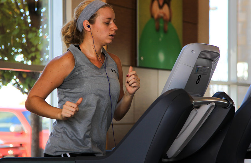 Angela Schroedle watches television on the P80 console touch screen while exercising at Peak Sports Club in Loves Park, Ill., last month.