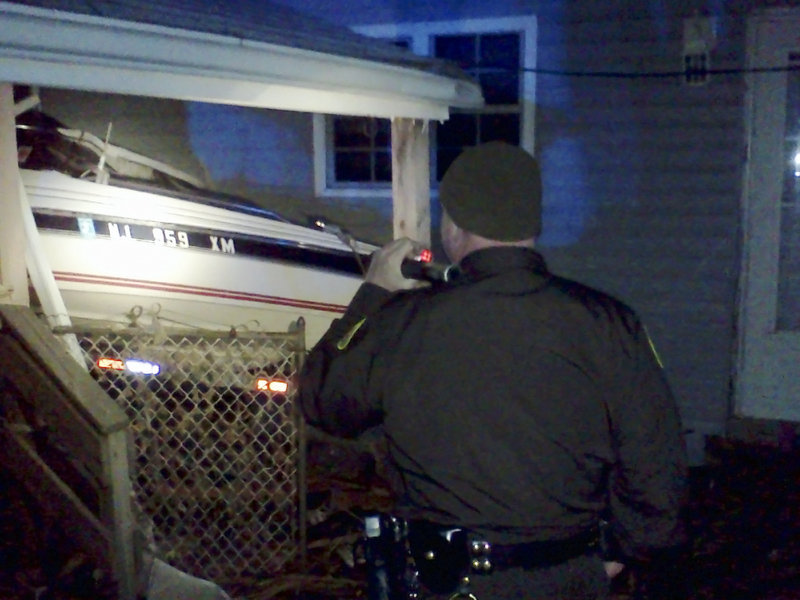 Cumberland County Sheriff’s Sgt. James Ambrose inspects a boat in Monmouth County that was washed onto a house porch by Superstorm Sandy. Ambrose and a contingent of Maine officers are helping police patrol the streets and enforce a 6 p.m.-to-6 a.m. curfew.