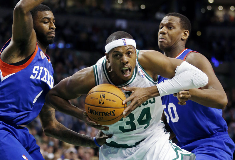 Boston’s Paul Pierce makes a determined drive to the basket while guarded by Philadelphia’s Dorell Wright, left, and Lavoy Allen during the second quarter of the 76ers’ 106-100 win over the Celtics at Boston on Friday night.