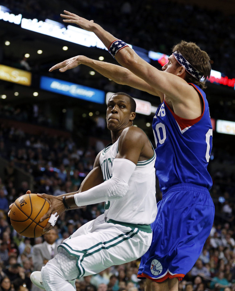 Boston’s Rajon Rondo, left, makes an inside move against Philadelphia’s Spencer Hawes. Rondo finished with 14 points and 20 assists, but the Celtics lost 106-100 and fell to 2-3.