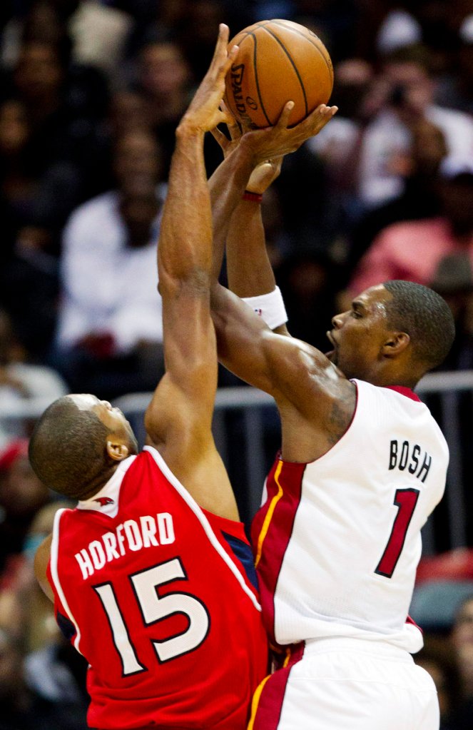 Miami Heat center Chris Bosh, right, has his shot blocked by Atlanta Hawks power forward Al Horford (15) in the first half of a 95-89 win by the Heat at Atlanta.