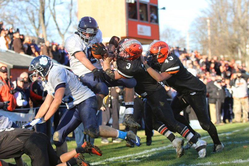 Dylan Hapworth, center, and C.J. Kelley knock Dirigo running back Spencer Trenoweth out of bounds during Winslow’s 17-6 victory Saturday in the Western Class C championship game at Winslow.