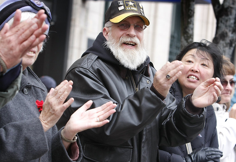 Stephen Betters of Portland and his wife, Sun, right, applaud the Portland Veterans Day parade Sunday. Stephen Betters served in the Army from 1973-1993.