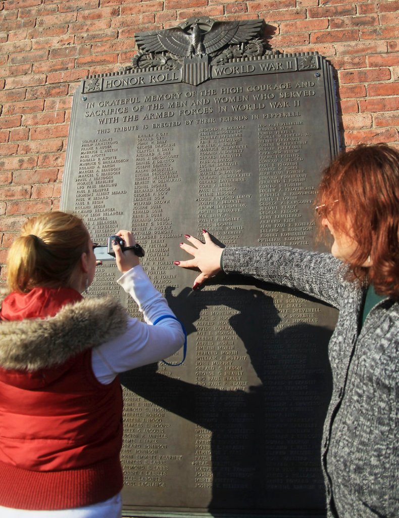 Roger Forest, right, of Old Orchard Beach locates the names of relatives listed on the Pepperell Co.’s World War II plaque as his daughter, Mariah Babine, also of Old Orchard Beach, takes a photograph.