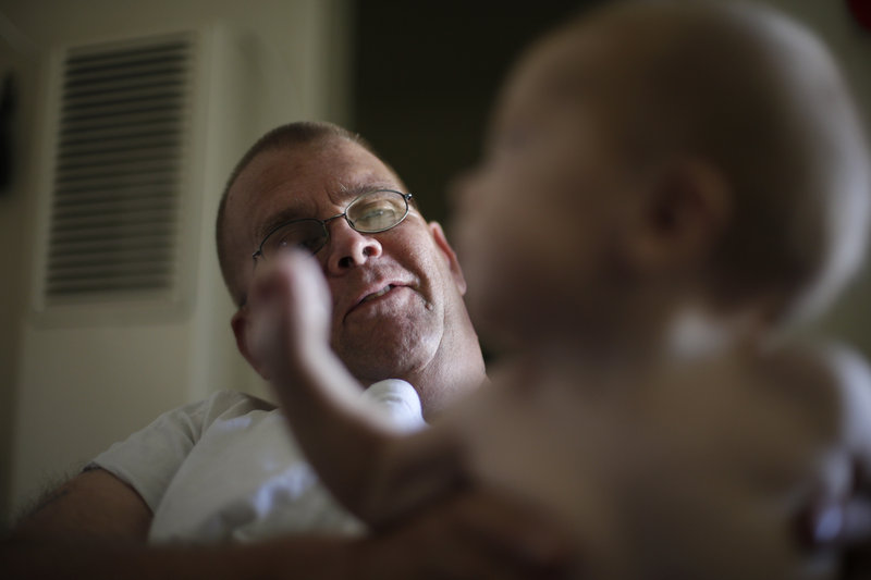 Arthur Lute holds his son, Evan. Lute’s journey from his days as a Marine to nights sleeping on the streets shows the challenge of ending homelessness among veterans by 2015.