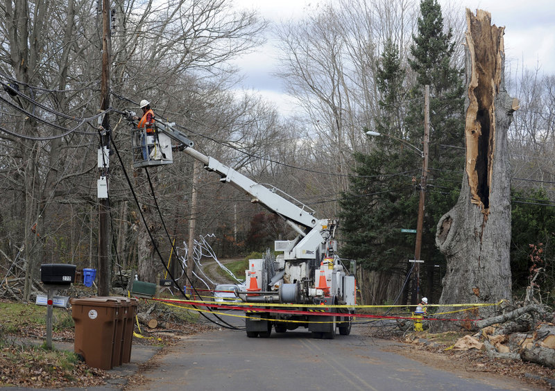 The Associated Press A crew from AT&T repairs lines near the remains of a 400-year-old oak tree in Shelton, Conn., which was toppled by wind gusts during Hurricane Sandy.
