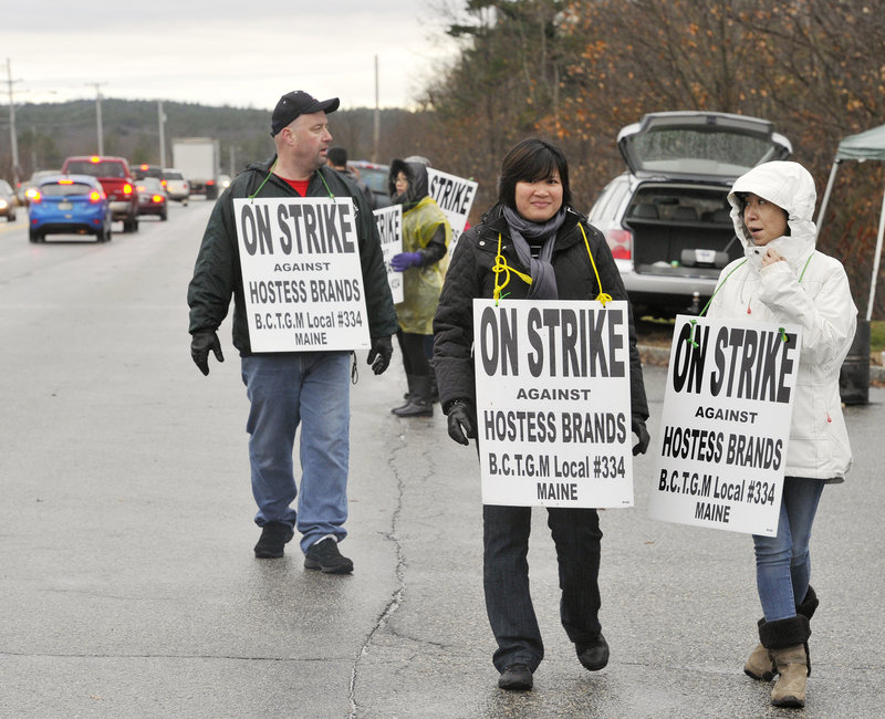 Union employees picket Tuesday outside the Hostess Brands plant in Biddeford to protest cuts in wages and benefits. The workers went on strike Friday evening after the last loaf of bread was wrapped.