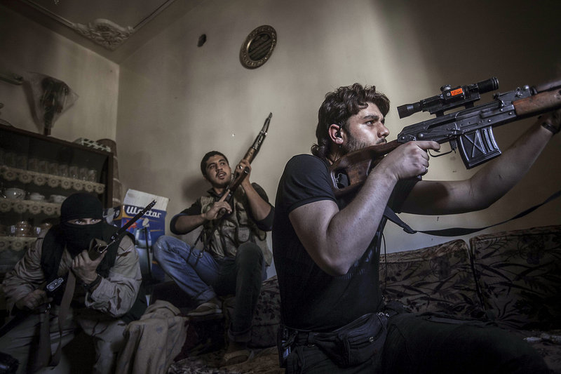 A rebel sniper aims at army positions in Syria. The rebels are seeking more powerful weapons from other countries.