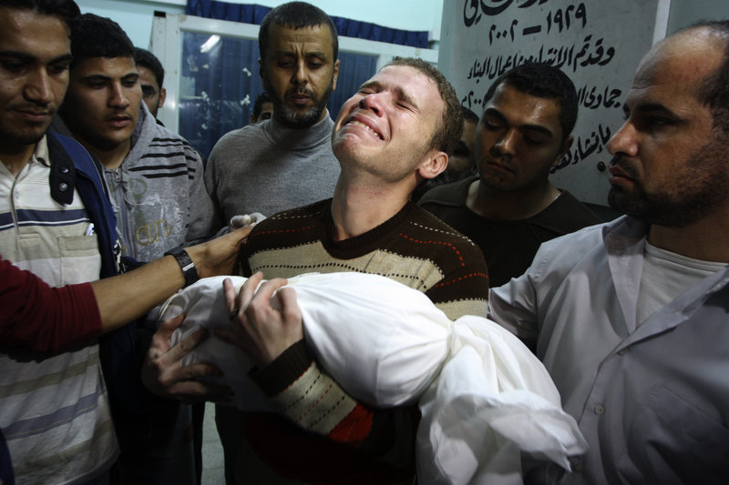 Jihad Masharawi weeps over the body of his 11-month-old son Ahmad after an Israeli air strike hit their home in Gaza City Wednesday. Israel’s attack killed at least 10 Palestinians.