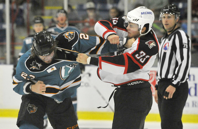 Mark Louis of the Portland Pirates, right, unleashes a punch against Matt Pelech of the Worcester Sharks during the first period of Worcester’s 4-2 victory Wednesday night at Lewiston. Each player received a major for fighting.