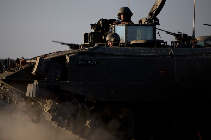 Israeli soldiers ride on an armored personnel carrier near the Gaza border Thursday. Israel’s prime minister says the army is prepared for a “significant widening” of its Gaza offensive.
