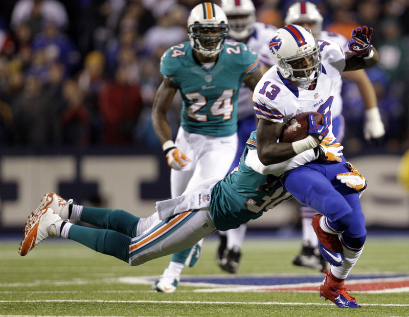 Stevie Johnson of the Buffalo Bills is brought down by strong safety Chris Clemons of the Miami Dolphins during the first half of the Bills’ 19-14 victory Thursday night.