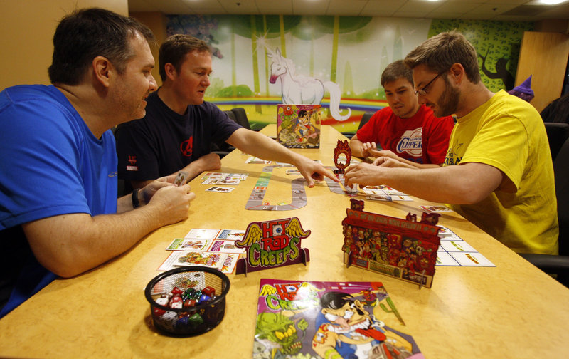 From left, Kyle Heuer, Matt Hyra, Will Brinkman and Phil Cape play Hot Rod Creeps, a card-driven racing game at Cryptozoic Entertainment in Irvine, Calif. The revival of board games has been driven in part by fans of digital games.