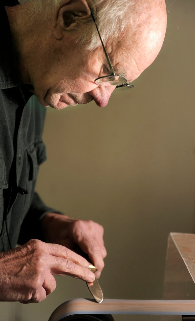Bruce Bohrmann sharpens a knife in his Yarmouth workshop earlier this month.